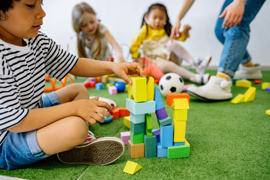 children work motor development by stacking blocks
